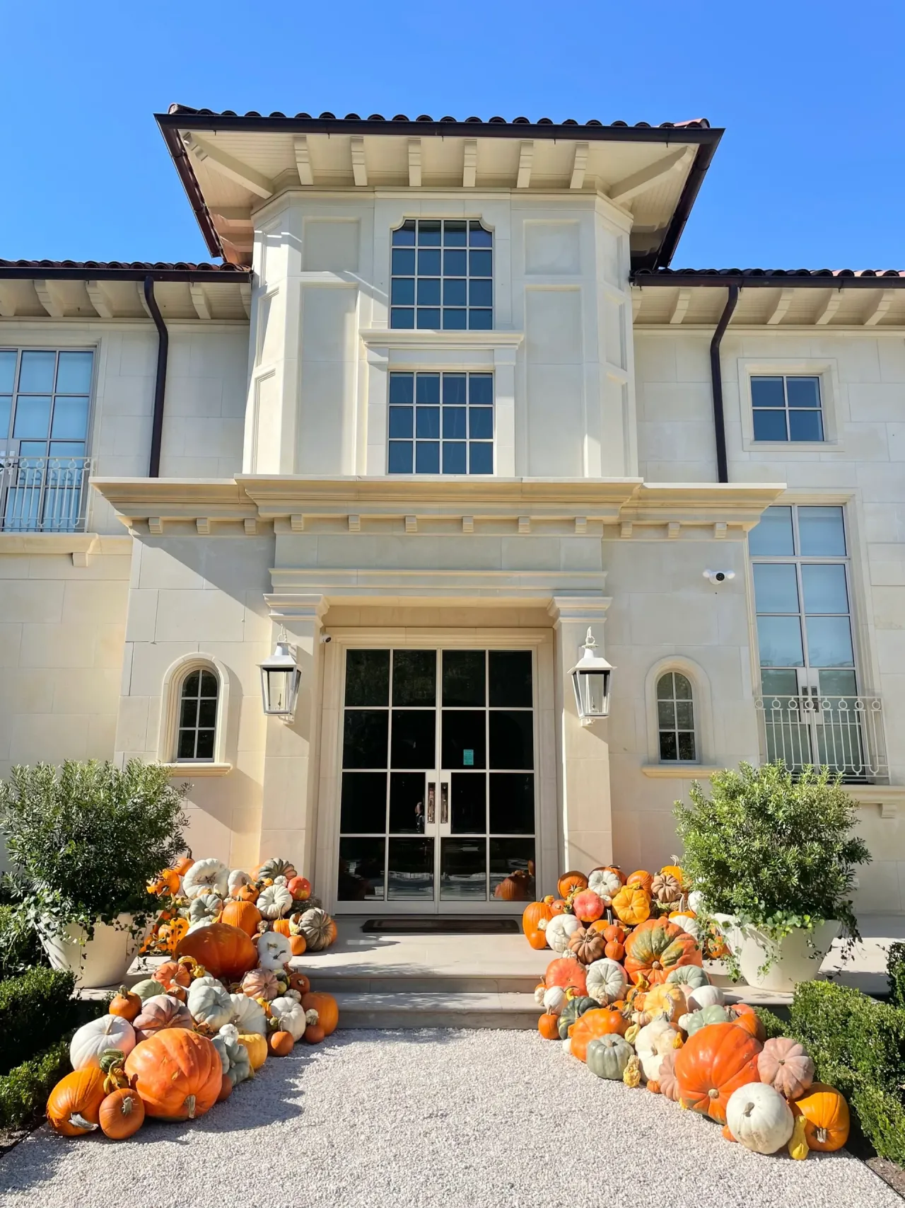 Pumpkin display cascading down the steps of a large stone estate entrance